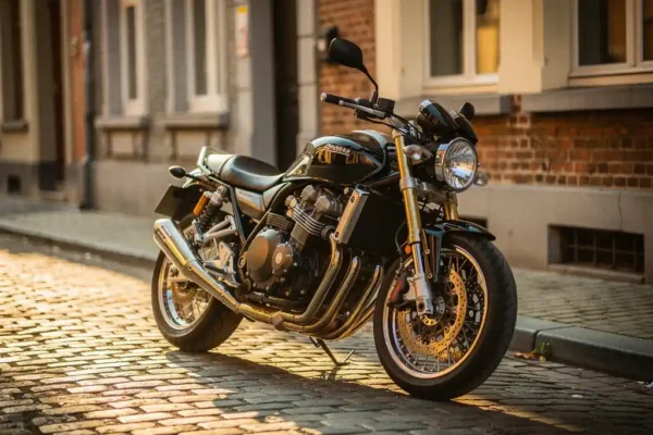 Gloednieuwe motorfiets geparkeerd op Belgische kasseien met aankoopsticker op het windscherm, gouden middaglicht.